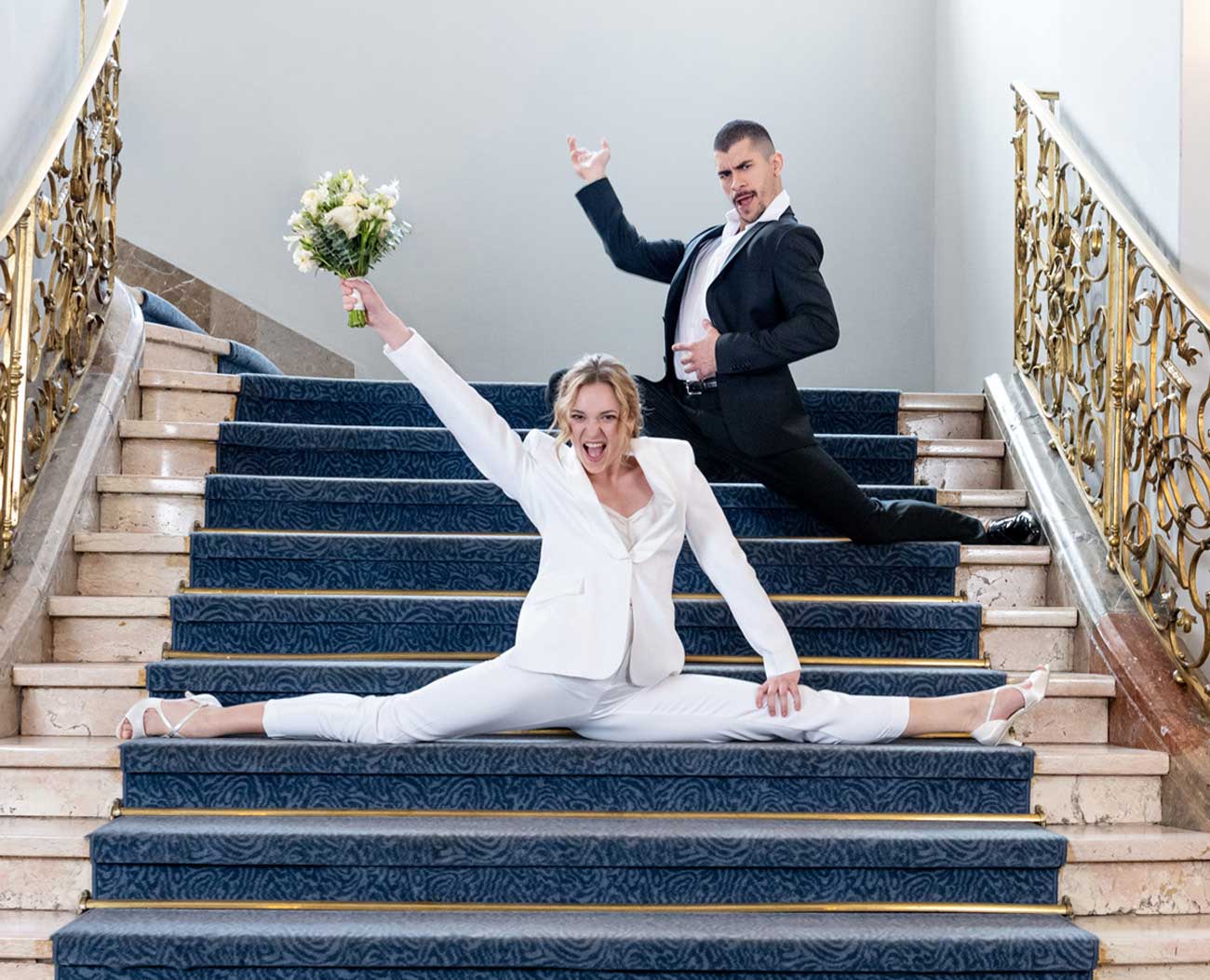 Une mariée fait le grand écart dans les escaliers en portant des chaussures de Werner Kern. 